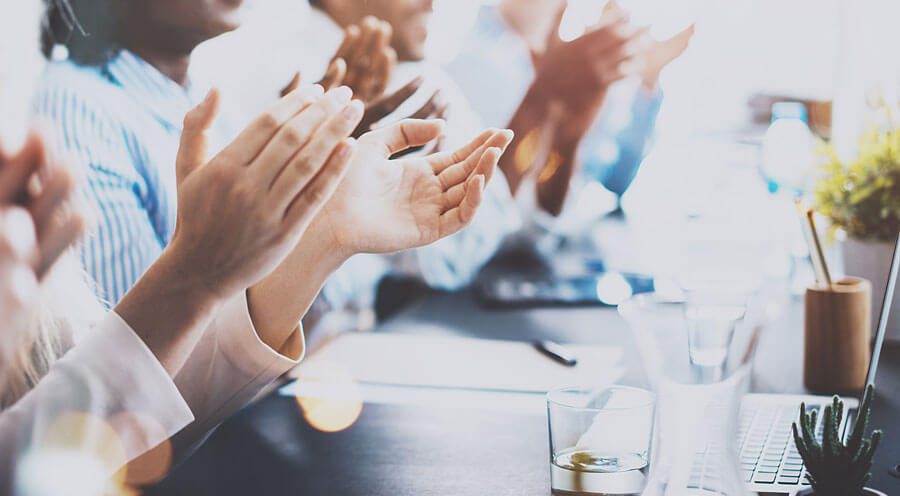 close-up of hands clapping in a business meeting